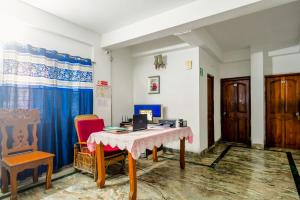 Habitación con mesa, 2 sillas y escritorio. en Puja Residency, en Thākurdwari