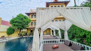a white canopy over a pool in front of a building at Villa Indochine d'Angkor in Siem Reap