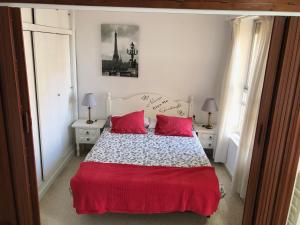 una camera con un letto con due cuscini rossi di PRIMERA LINEA DE PLAYA, VISTAS AL MAR a Algarrobo-Costa