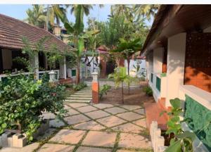 a courtyard of a house with a walkway at Hotel Holiday Home in Kovalam