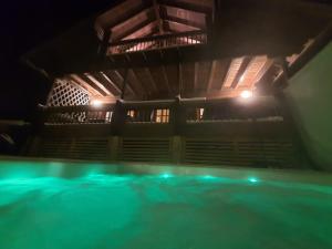 una piscina cubierta con luces verdes por la noche en Villa Nurminiemi, en Koro