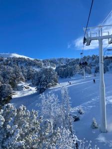 尚魯斯的住宿－Chamrousse - Résidence Eterlou，滑雪缆车,人们在雪覆盖的斜坡上滑雪