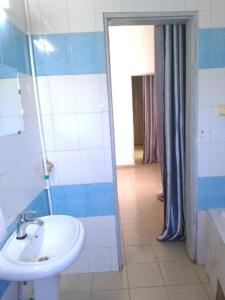 y baño con lavabo y ducha. en Appart meublé le Dakota, en Yaoundé