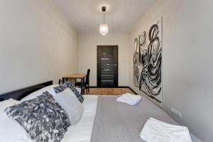 sypialnia z białym łóżkiem i obrazem na ścianie w obiekcie Aquarius by Grand Apartments w mieście Sopot