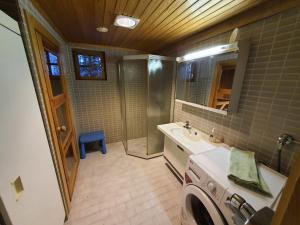 y baño con lavabo y lavadora. en Villa Nurminiemi, en Koro