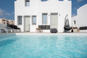a villa with a swimming pool in front of a house at White Orchid Suites in Vóthon