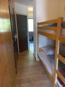 a room with two bunk beds and a hallway at Appartement au Sommand au pied des pistes in Mieussy