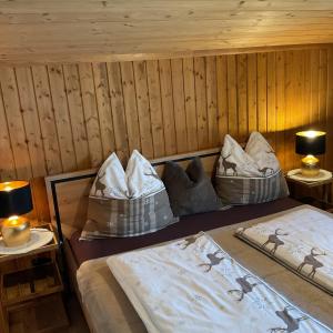 a room with two beds and two lamps in a cabin at Haus Asslaber in Hochfilzen