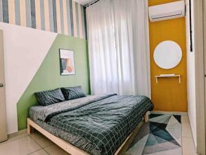 1 dormitorio con 1 cama con pared verde en Paradise Villa Kempas Utama en Skudai