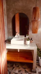 een badkamer met een witte wastafel en een spiegel bij Villa Maria in Uruçuca