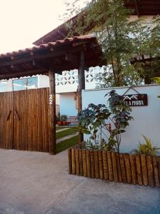 een huis met een houten hek en een bord bij Villa Maria in Uruçuca