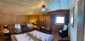a bedroom with a bed and a chair and a window at Haus Asslaber in Hochfilzen