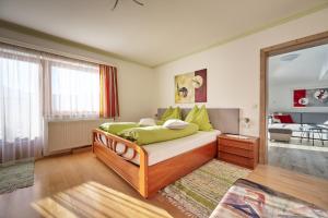 ein Schlafzimmer mit einem Bett mit grünen Kissen in der Unterkunft Ferienwohnung Familie Wieser in Altenmarkt im Pongau