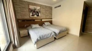een slaapkamer met een bed en een bakstenen muur bij Luxurious cozy apartment in Amman