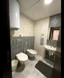 a bathroom with a toilet and a sink at Luxurious cozy apartment in Amman