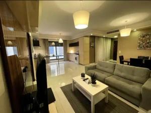 sala de estar con sofá y mesa en Luxurious cozy apartment, en Amán