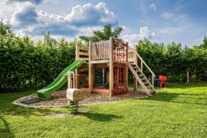 a wooden playground with a slide in the grass at U potůčku in Malá Morávka