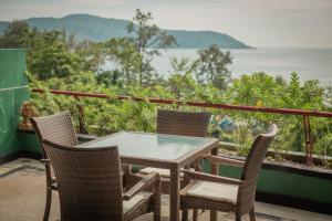 a table and chairs on a balcony with a view at Kata Prime in Kata Beach