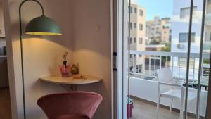 a room with a table and a chair and a balcony at STAY Sunlit Apartment in Limassol