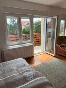 1 dormitorio con 1 cama y balcón con ventanas en Vila Vera en Divčibare