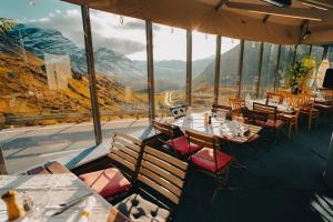 ein Restaurant mit Tischen und Stühlen und Bergblick in der Unterkunft Ospizio La Veduta in Bivio