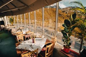 a restaurant with tables and chairs with a view of a mountain at Ospizio La Veduta in Bivio