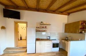 a kitchen with white appliances and a wooden floor at Visoravan 1200 in Kupres