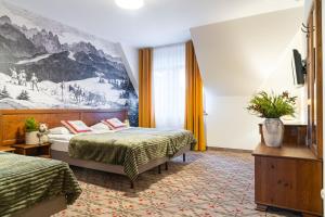 a hotel room with two beds and a painting on the wall at Pensjonat Maria 5 in Zakopane