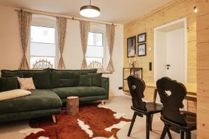 奥泊维森塔尔Chalet Erwin的客厅配有绿色沙发和两把椅子