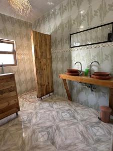 a bathroom with a tiled floor with a sink and a counter at DAR SANAE SURF in Aourir