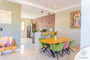 a kitchen and dining room with a wooden table and green chairs at Villa Boutique Amani in Marrakech