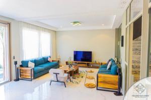 a living room with blue couches and a tv at Villa Boutique Amani in Marrakesh