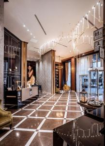 a lobby with a large tiled floor with chandeliers at David Tower Hotel Netanya by Prima Hotels - 16 Plus in Netanya