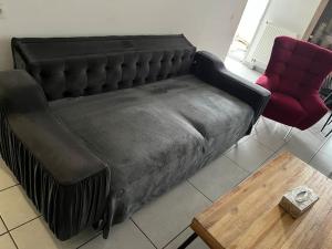 un sofá de cuero negro en una sala de estar con mesa en Joliette , 4 chambres, wifi, en Marsella