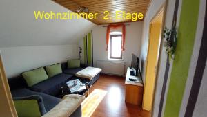 a living room with a couch and a tv at Ferienwohnung Rüfflerstub in Eibenstock
