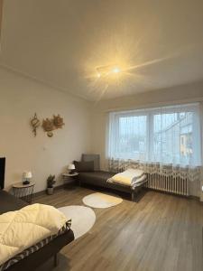 sala de estar con 2 camas y ventana en Cozy Appartement Belvaux en Belvaux