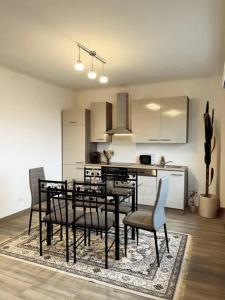 kuchnia ze stołem i krzesłami w pokoju w obiekcie Cozy Appartement Belvaux w mieście Belvaux