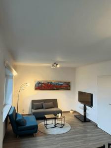 a living room with a couch and a television at Cozy Appartement Belvaux in Belvaux