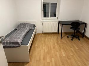 Schlafzimmer mit einem Bett, einem Schreibtisch und einem Tisch in der Unterkunft Home in Lahr