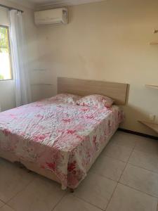 um quarto com uma cama com um cobertor rosa em Apartamento Ocean View Tabatinga em Nísia Floresta