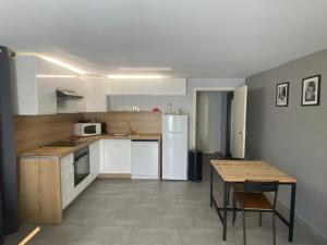 een keuken met witte kasten en een tafel met stoelen bij sol y mar 2 in Saint-Aygulf