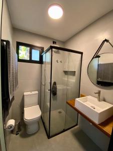 uma casa de banho com um chuveiro, um WC e um lavatório. em Villa Julião em Ilhabela