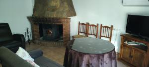 a living room with a fireplace with a couch and a table at Alojamiento Rural El Molino De La Cerrada in Castril +66 photos