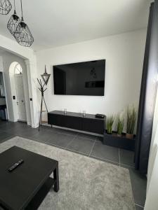 ein Wohnzimmer mit einem Flachbild-TV an der Wand in der Unterkunft Duplex avec extérieur privatif proche Paris/CDG in Livry-Gargan
