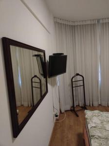 a room with a mirror and a tv and a bed at Flat completo - Campinas Centro in Campinas