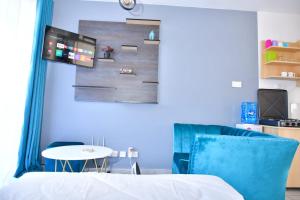 ナイロビにあるAqua Modern Studio Near Ngong Roadのベッド、テーブル、テレビが備わる客室です。