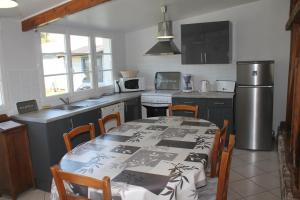 Gueschart的住宿－Ferme du lin : Rosalin，厨房配有桌椅和冰箱。