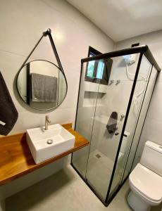 uma casa de banho com um lavatório e um espelho em Villa Julião em Ilhabela