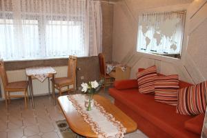 ein Wohnzimmer mit einem Sofa und einem Tisch in der Unterkunft Top Hotel Edingen in Edingen-Neckarhausen