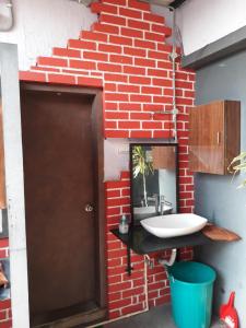 a bathroom with a sink and a brick wall at Lotus View Living by Three Peace Soup in Hyderabad